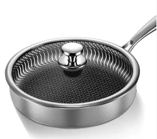Stainless steel frying pan with glass lid on a white background